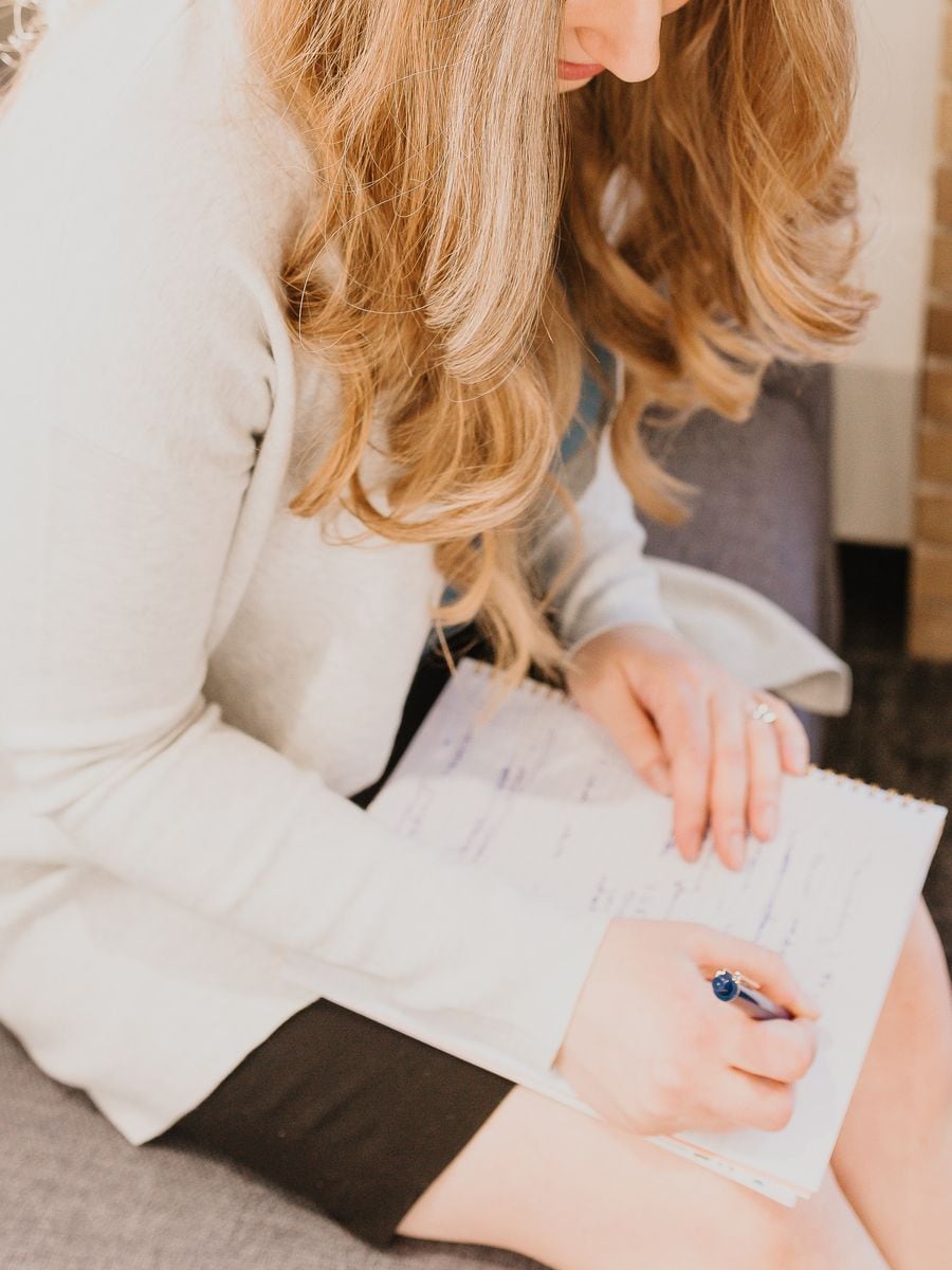 Krista Evanisky writing notes on a legal pad during a client meeting