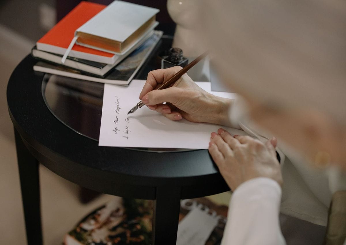 A woman writing a letter to her daughter with a fountain pen
