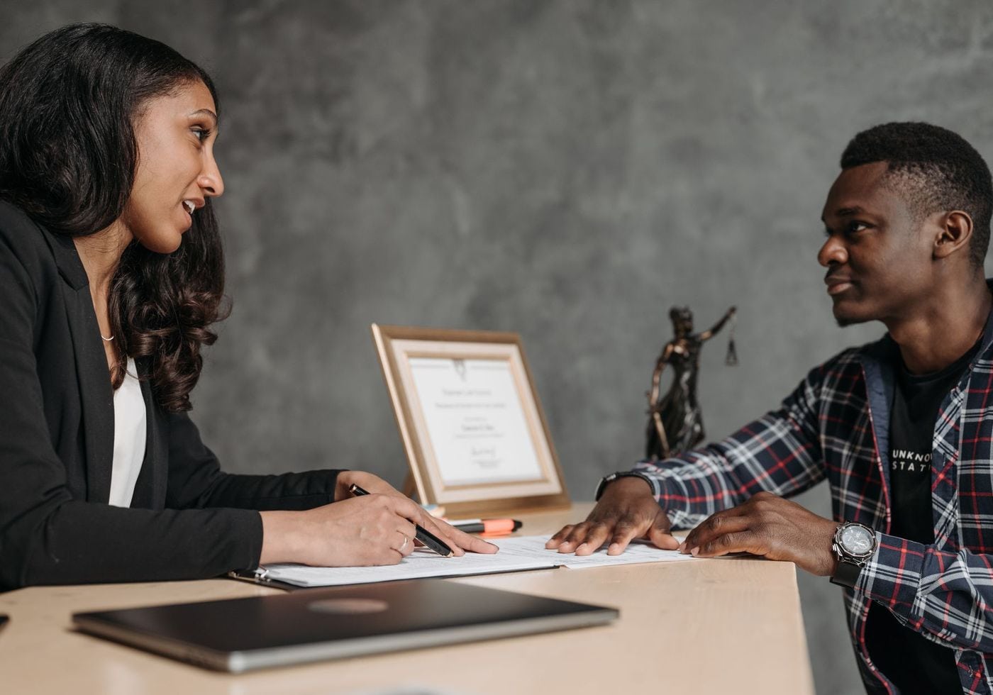 A lawyer walking a client through documents across an office desk